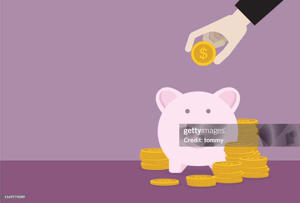 Businessman putting dollar coin into a piggy bank