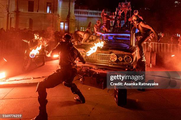 Performers a part of the Mad Max: Fury Road live performance as a fire twirler twist a baton during White Night Melbourne Reimagined on August 23,...