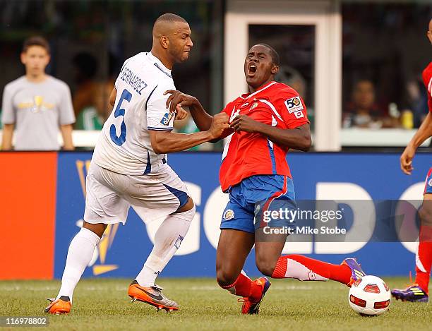 Osman Chavez of Costa Rica is knocked to the ground by Celso Borges of Honduras during the 2011 Gold Cup Quarterfinals on June 18, 2011 at the New...