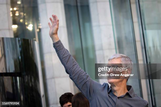 Apple CEO Tim Cook waves to customers before they enter Apple's flagship 5th Avenue store to purchase the new iPhone 11 on September 20, 2019 in New...