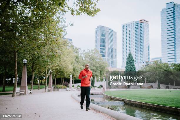 athlete running in bellevue city park - center athlete stock pictures, royalty-free photos & images