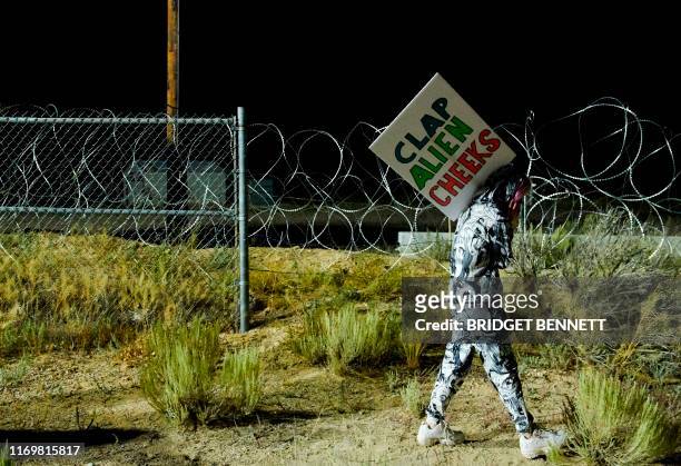 Attendee Ellie Urquhart walks past a security line as people gather to "storm" Area 51 at an entrance to the military facility near Rachel, Nevada on...