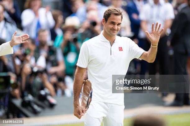 Roger Federer of Switzerland with the runners up plate after defeat by Novak Djokovic of Serbia after the Men's Singles Final at The Wimbledon Lawn...