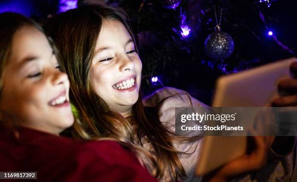 beautiful girls at christmas eve watching movie - christmas movie stock pictures, royalty-free photos & images