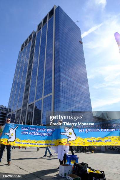 Activists with a banner 'Do not miss the big fortunes. Long live the right tax.' poses in front of the Brussels Finance Tower during the Third...