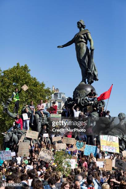 Paris, France, 20 September 2019. Young climate protesters stand on the statue of the nation's square holding many signs to the message to defend the...