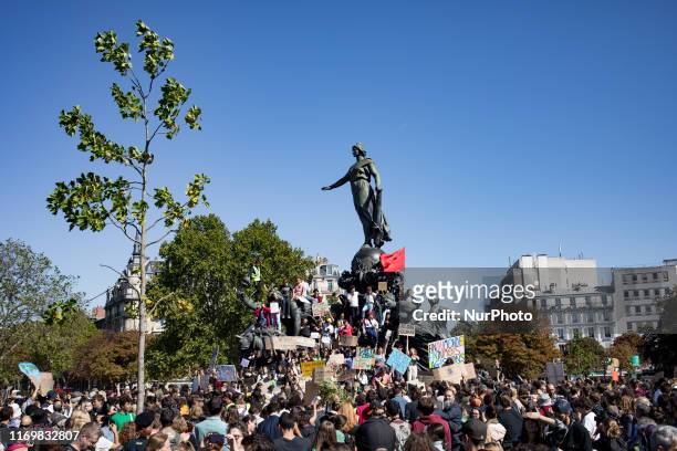 Paris, France, 20 September 2019. Young climate protesters stand on the statue of the nation's square holding many signs to the message to defend the...