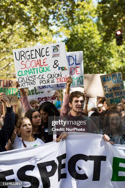 Paris, France, 20 September 2019. Young climate protesters march past holding many signs with the message to defend the planet and against climate...