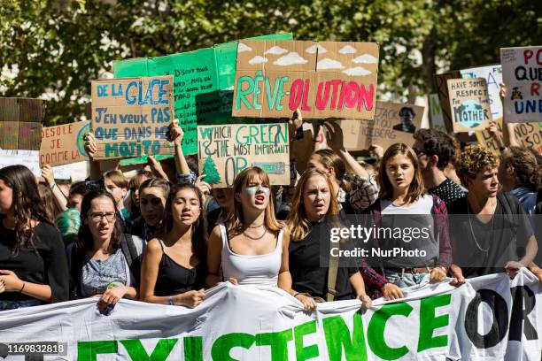 Paris, France, 20 September 2019. Young climate protesters march past holding many signs with the message to defend the planet and against climate...