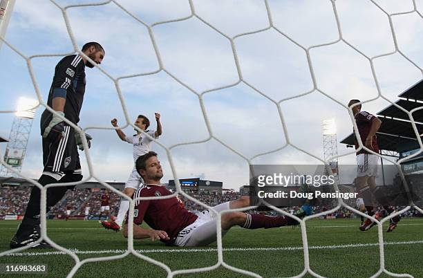 Drew Moor of the Colorado Rapids sits on the turf after scoring an own goal in the 25th minute as Mike Magee of the Los Angeles Galaxy celebrates as...