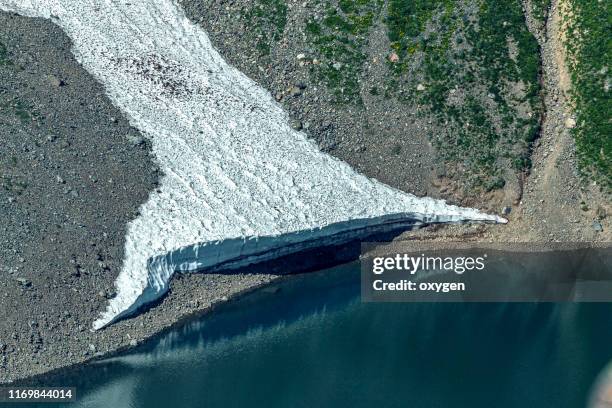 ice snow near lake water in valley of rocky slope in summer day, altai, russia - river bottom park stock pictures, royalty-free photos & images