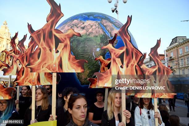 Students and activists hold up a globe as they take part during the Global Climate Strike march downtown Zagreb, Croatia, on September 20, 2019....