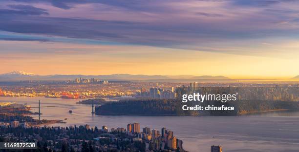 the north vancouver skyline at twilight and snow mountains visible in the background - vancouver skyline stock pictures, royalty-free photos & images