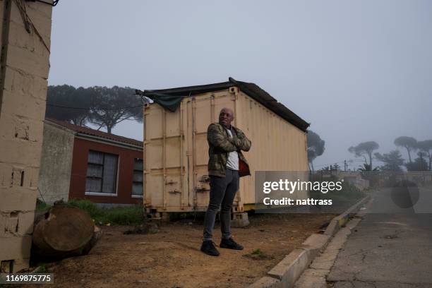 african man standing with his arms crossed in the township - south african culture stock pictures, royalty-free photos & images