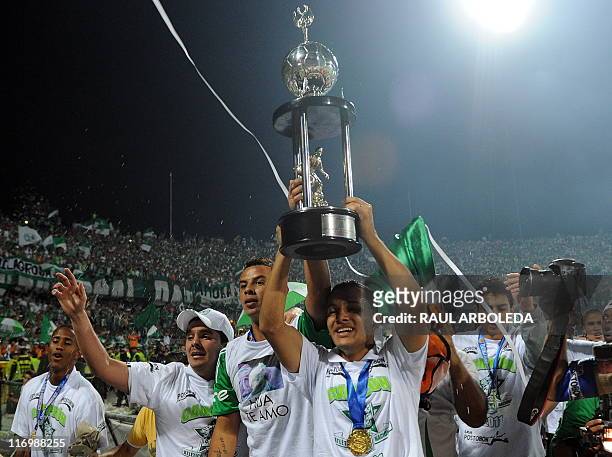 Atletico Nacional's footballers celebrate with the trophy after defeating La Equidad during the Colombian Soccer League final match in Medellin,...
