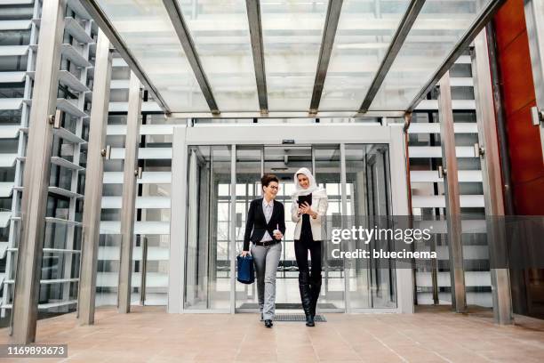 business people quitting the office building - building lobby stock pictures, royalty-free photos & images