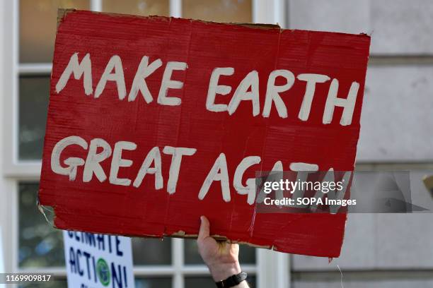 Protester holds a placard that says make earth great again during the demonstration. Adult and youth walking out of work and schools to demand for an...