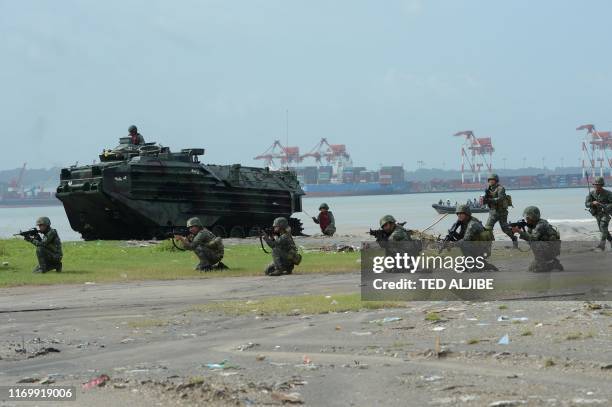 Philippine marines take their position next to newly-acquired Amphibious Assault Vehicles during an amphibious landing exericse at the lighthouse...