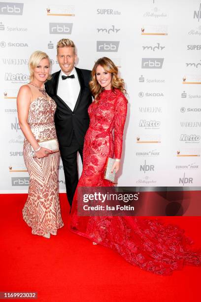 German actress Kamilla Senjo, German singer and presenter Maximilian Arland and German presenter Mareile Hoeppner attend the Goldene Henne at Messe...