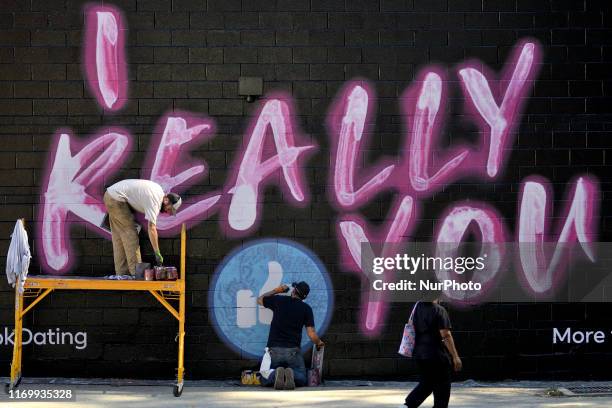 People walk past an advertisement for the Facebook dating service on a sidewall in the Germantown neighborhood of Philadelphia, PA., on September 20,...