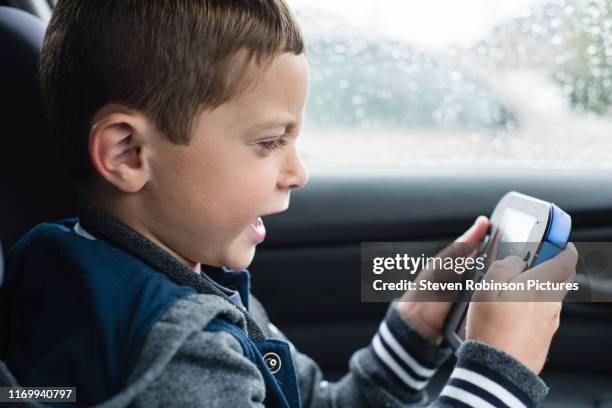 boy frustrated playing games console - pocket electronic game stock pictures, royalty-free photos & images