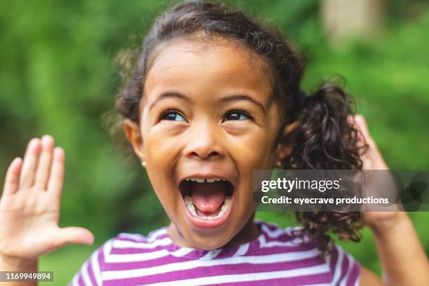 four year old african american chinese ethnicity girl posing for portrait in lush green outdoor back yard setting - excitement stock pictures, royalty-free photos & images