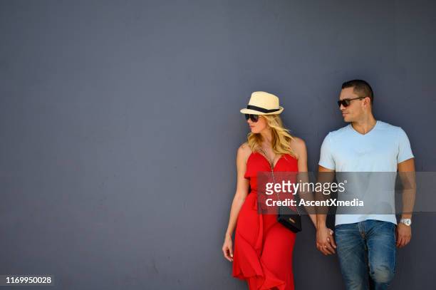 multi-ethnic couple leaning on gray wall in city - wynwood stock pictures, royalty-free photos & images