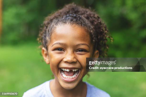 six year old african american chinese ethnicity girl posing for portrait in lush green outdoor back yard setting - smiling teeth stock pictures, royalty-free photos & images