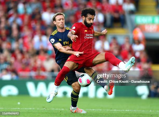 Mohamed Salah of Liverpool is challenged by Nacho Monreal of Arsenal during the Premier League match between Liverpool FC and Arsenal FC at Anfield...