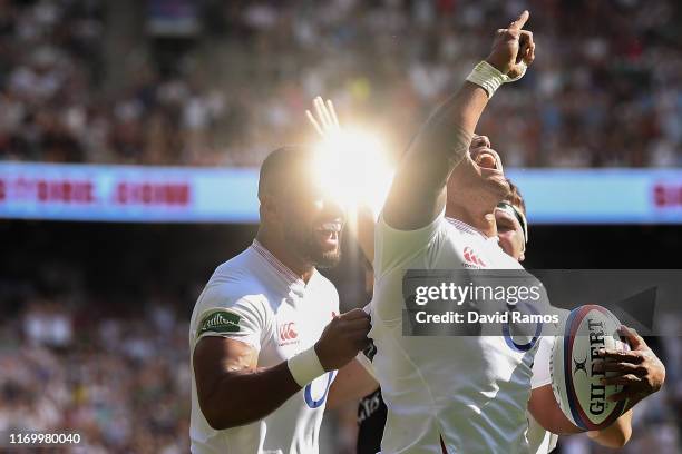 Manu Tuilagi of England celebrates with his team mates Joe Cokanasiga and Tom Curry after scoring his team's third try during the 2019 Quilter...