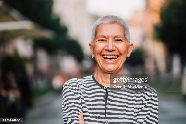 porträt einer fröhlichen seniorin - coole oma stock-fotos und bilder