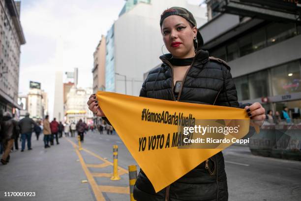 Woman holds a sign that reads in Spanish 'I vote for Macri' during a march in support of President Mauricio Macri, on August 24, 2019 in Buenos...