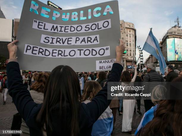 Woman holds a sign that reads in Spanish 'Republic: Fear only serves to lose everything' during a march in support of President Mauricio Macri on...