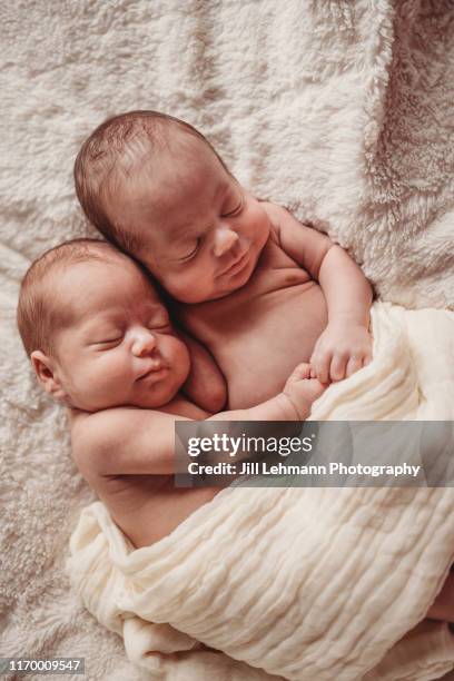 beautiful newborn twin baby boys sleep soundly together on white blankets - fraternal twin stock pictures, royalty-free photos & images