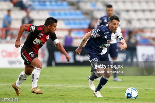 Osvaldo Martinez of Atlas fights for the ball with Rubens Sambueza of Pachuca during the 6th round match between Pachuca and Atlas as part of the...