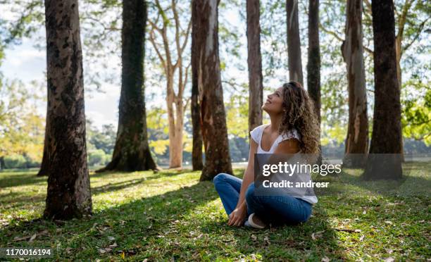 happy woman relaxing at the park - woodland floor stock pictures, royalty-free photos & images