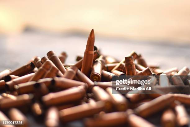 a bunch of fired bullet rounds of a gun / weapon. recent act of terrorism / killing / genocide / mass murder / shooting against civilians and muslims for ethnic cleansing requires gun laws legislation - shooting a weapon - fotografias e filmes do acervo