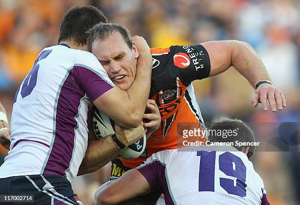 Gareth Ellis of the Tigers is tackled during the round 15 NRL match between the Wests Tigers and the Melbourne Storm at Leichhardt Oval on June 19,...