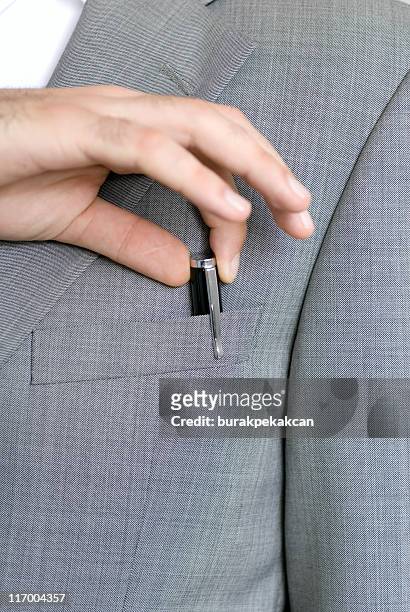 businessman hand pulls pen from suit pocket - businessman hands in pockets stock pictures, royalty-free photos & images