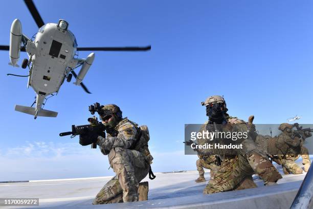 In this photo provided by South Korean Navy, South Korean Navy's special forces participate during the drill on the islets called Dokdo in Korean and...