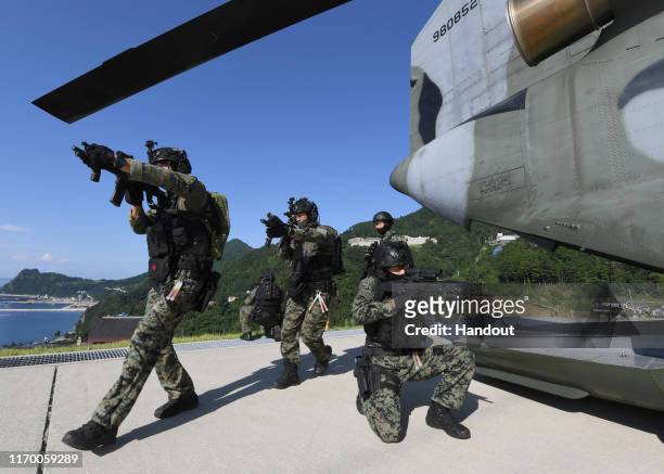 In this photo provided by South Korean Navy, South Korean Army's special forces participate during the drill on the islets called Dokdo in Korean and...