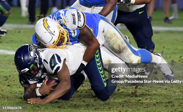 Linebacker Chris Peace of the Los Angeles Chargers sacks quarterback Geno Smith of the Seattle Seahawks in the second half of a pre-season NFL...