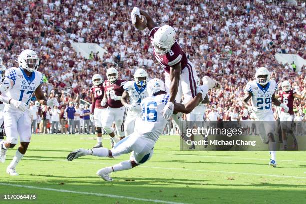 Running back Kylin Hill of the Mississippi State Bulldogs leaps for more yards while being hit by defensive back Brandin Echols of the Kentucky...
