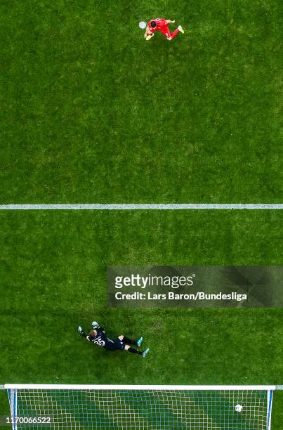 Robert Lewandowski of Bayern Muenchen scores his teams first goal from the penalty spot against Alexander Nübel of Schalke during the Bundesliga...