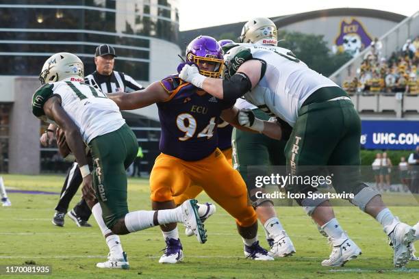 East Carolina Pirates defensive lineman Alex Turner gets held by William & Mary Tribe offensive lineman Dan Evers chasing down William & Mary Tribe...