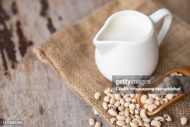 soy milk on a wooden table - milchkrug stock-fotos und bilder