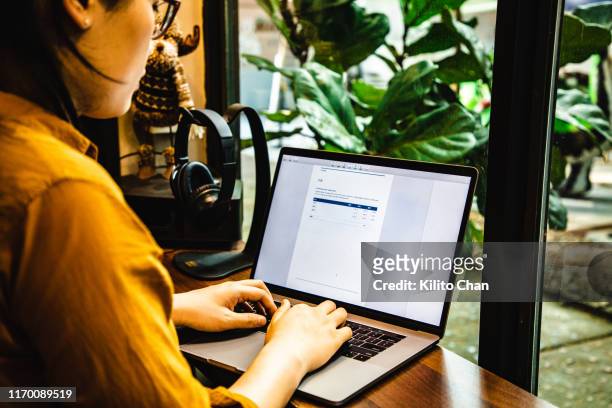 asian businesswoman using a laptop to write a report - writing email stock pictures, royalty-free photos & images