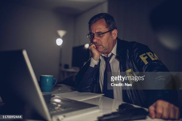 agente senior che lavora fino a tardi - fbi agents foto e immagini stock