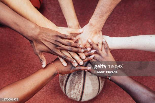 basketball team stacking hands in the court - basketball sport team stock pictures, royalty-free photos & images
