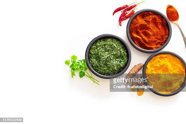 spices: turmeric, pepper powder and dried parsley shot from above on white background - spice stock pictures, royalty-free photos & images